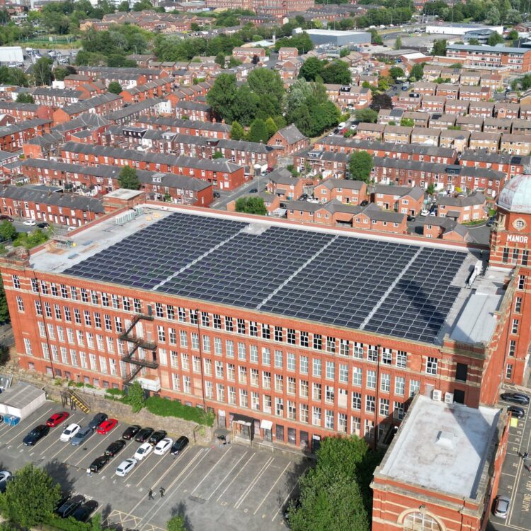 Aerial photograph of a commercial solar panel installation on the roof of a mill.