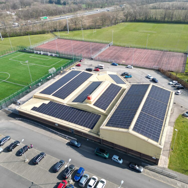 Aerial photograph of a commercial solar panel installation on the roof of a school.